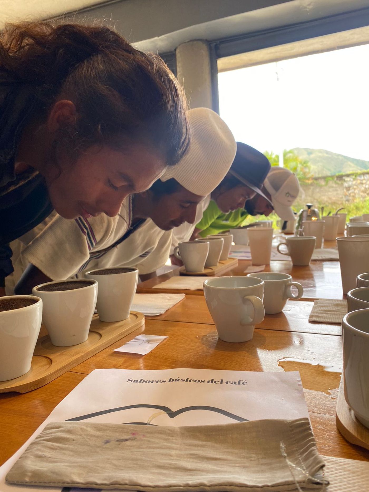 Jóvenes arhuacos catando café sobre la mesa de cata