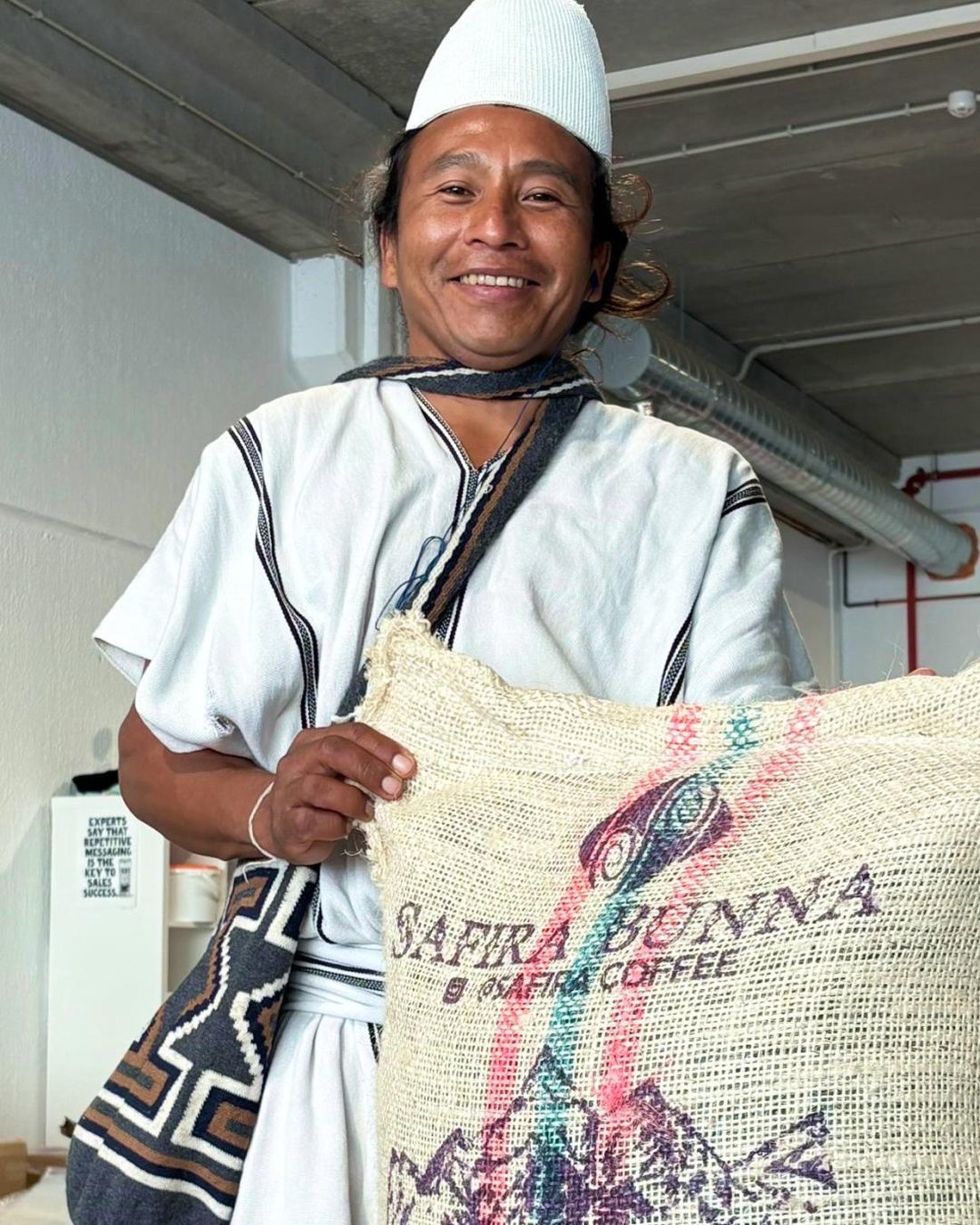 Oliverio Villanafia sosteniendo el saco de fique de Safira Bunna